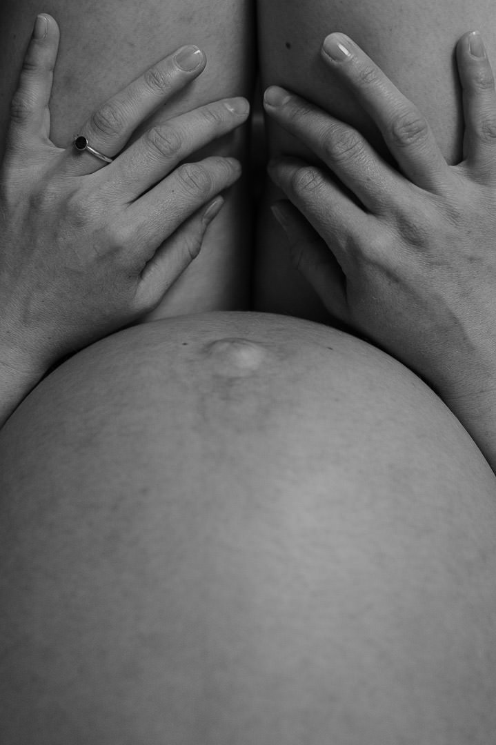 Babybauch und Hände auf Beinen