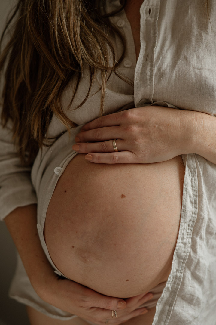 Babybauch wird von Händen gestreichelt