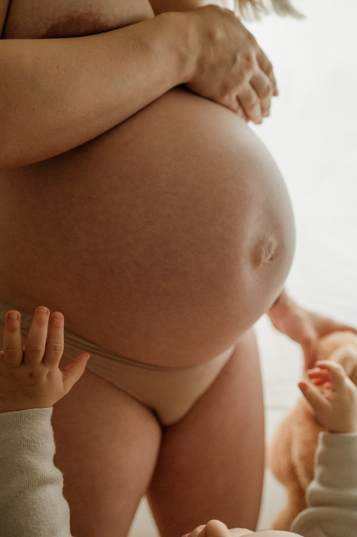 Kleinkindhände greifen nach Babybauch
