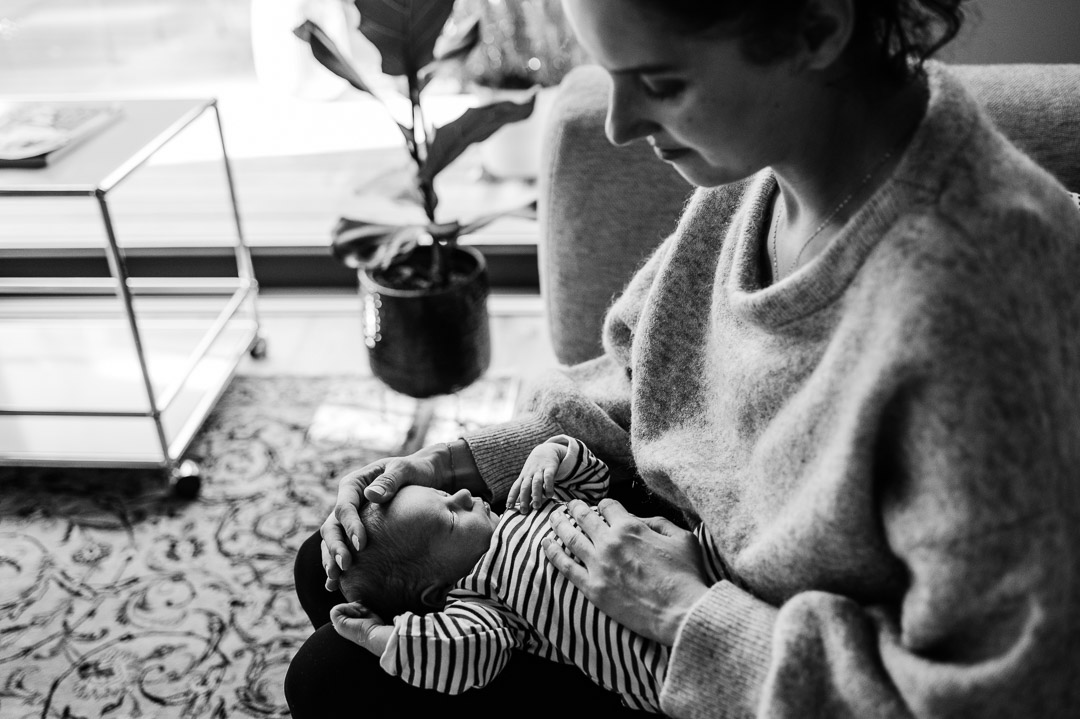 Mama streichelt Baby auf ihrem Schoss