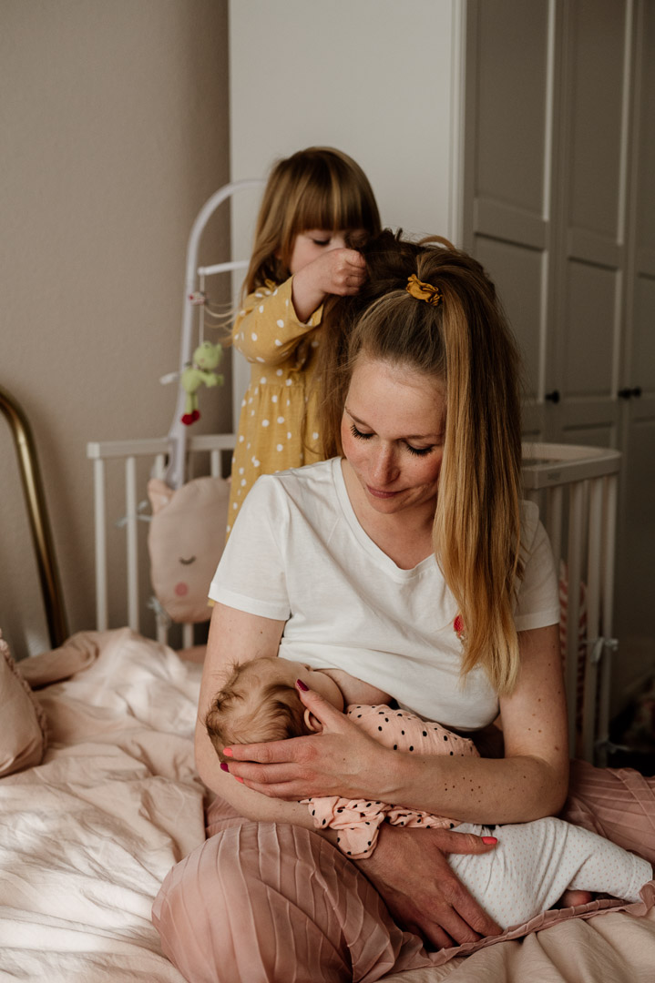 stillende Mama bekommt von Kleinkind die Haare gemacht