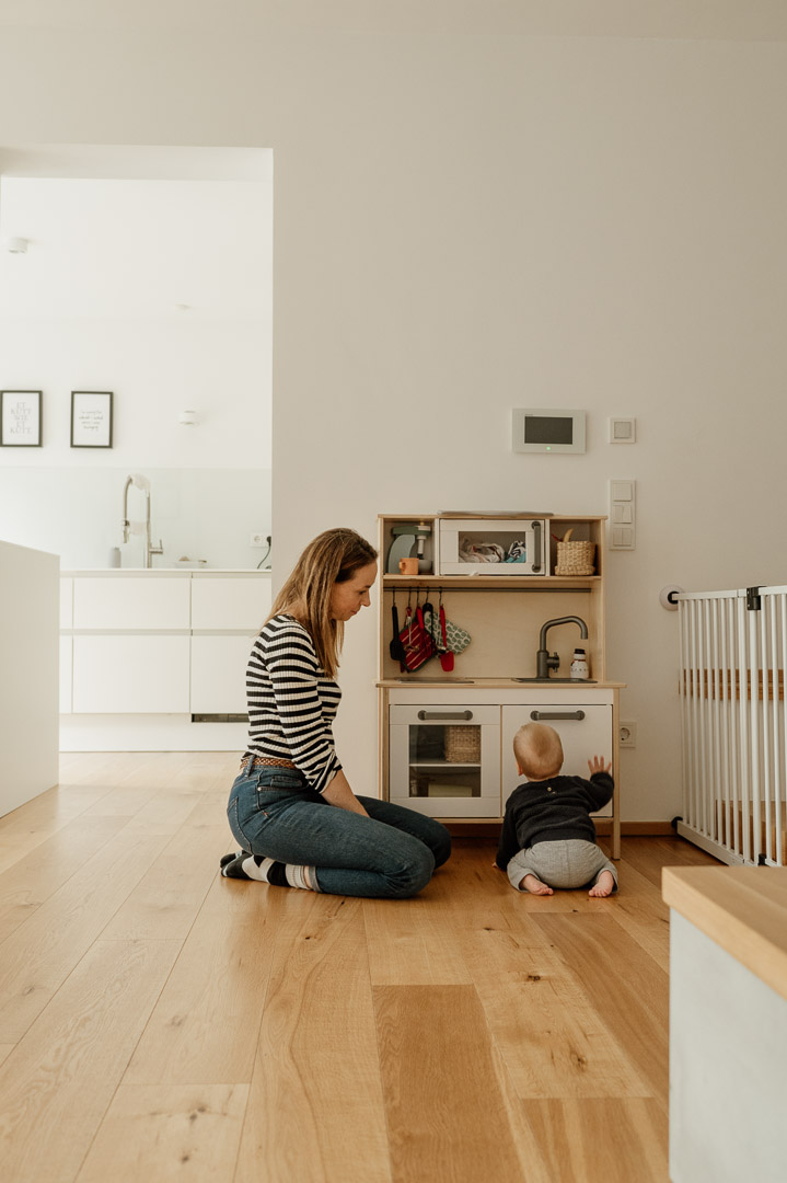 Mama und Kleinkind spielen mit Kinderküche