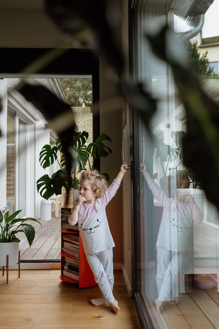 Mädchen spiegelt sich im Fenster der Terassentür