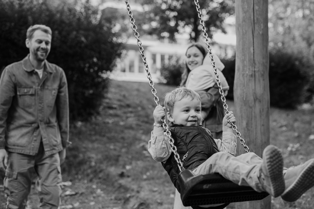 Familie schaukelt auf Spielplatz