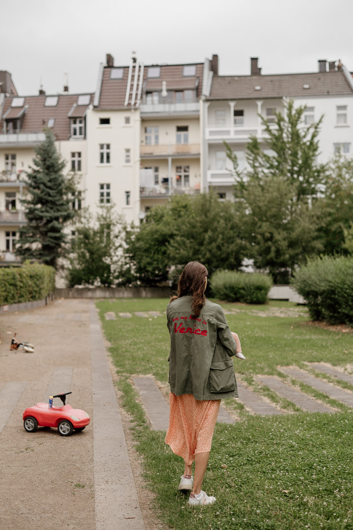 Frau steht im Hinterhof