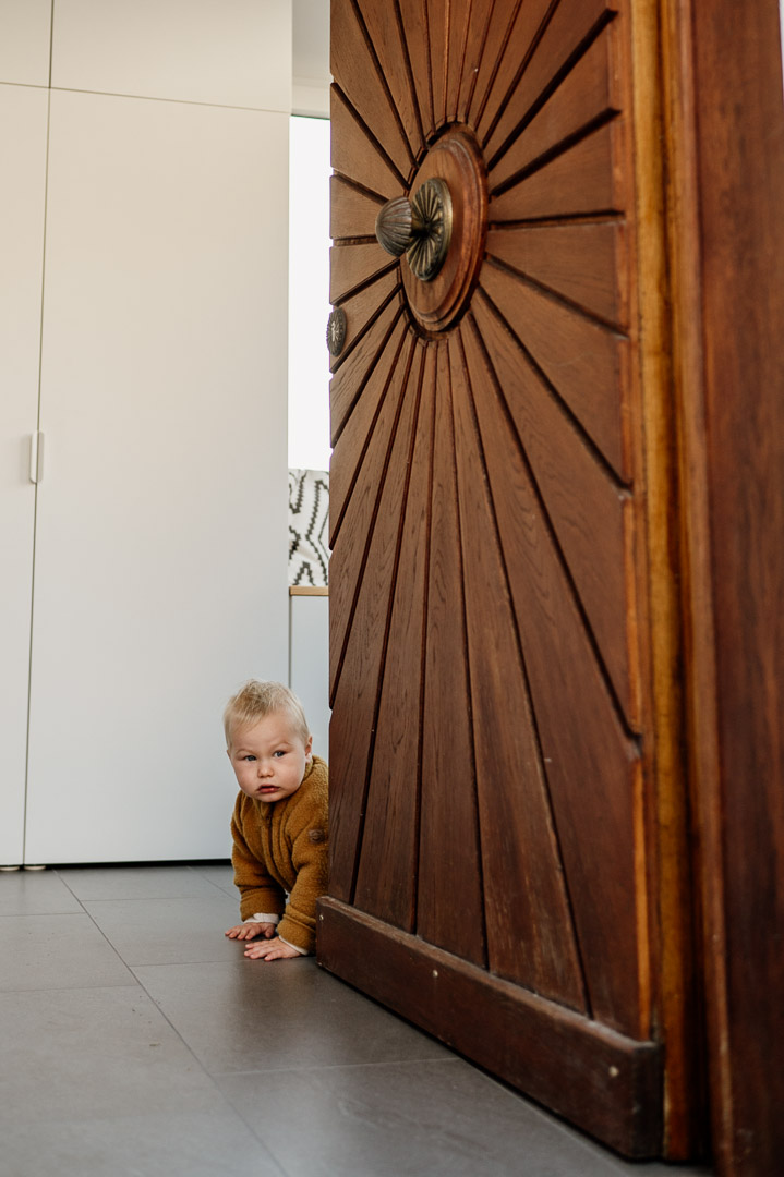 Baby lukt hinter Haustür hervor