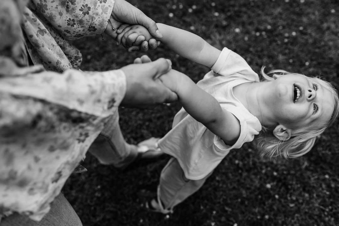 Kleinkind hängt sich an die Arme seiner Mama