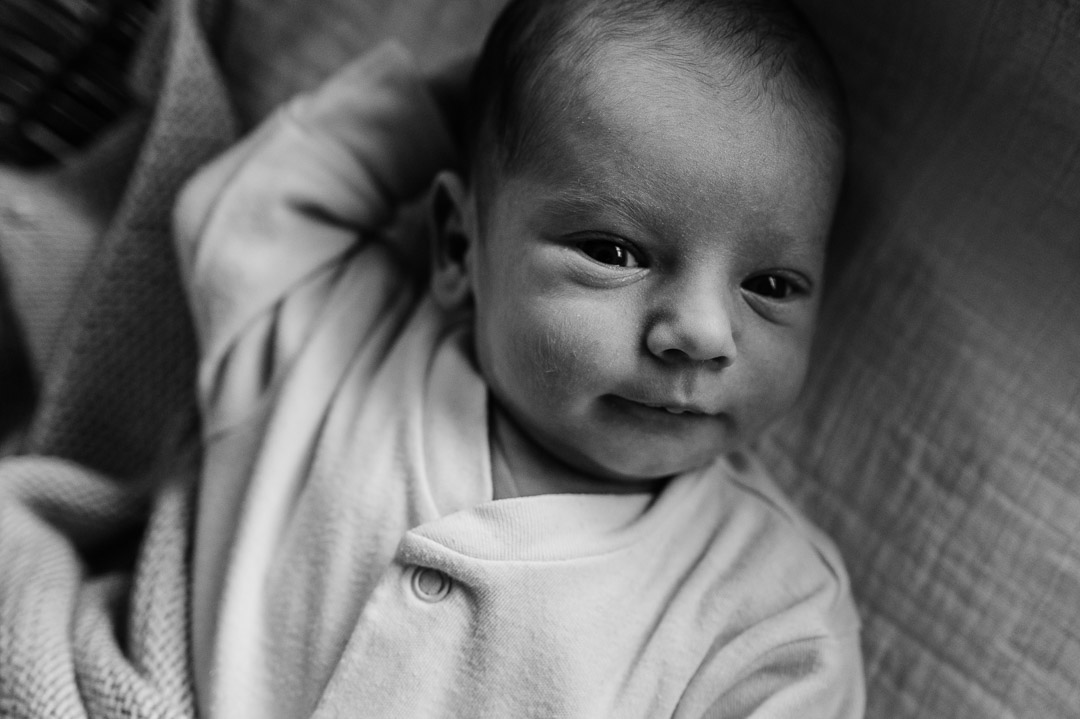 Baby in Strampler schaut in Kamera