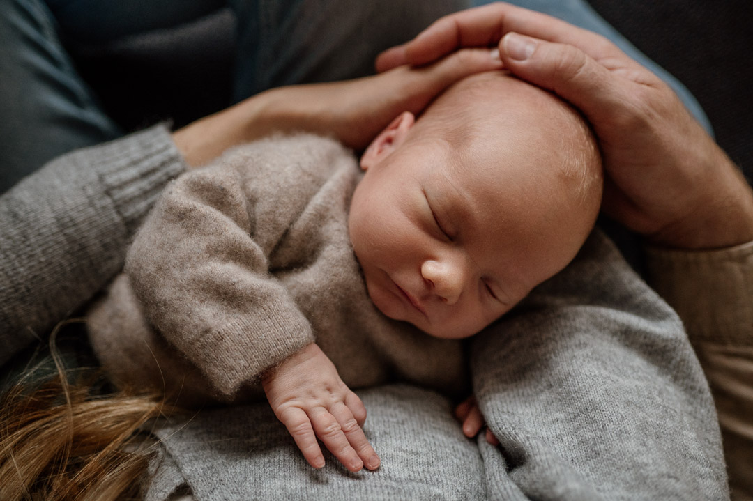 Baby in den Armen von Mama und Papa