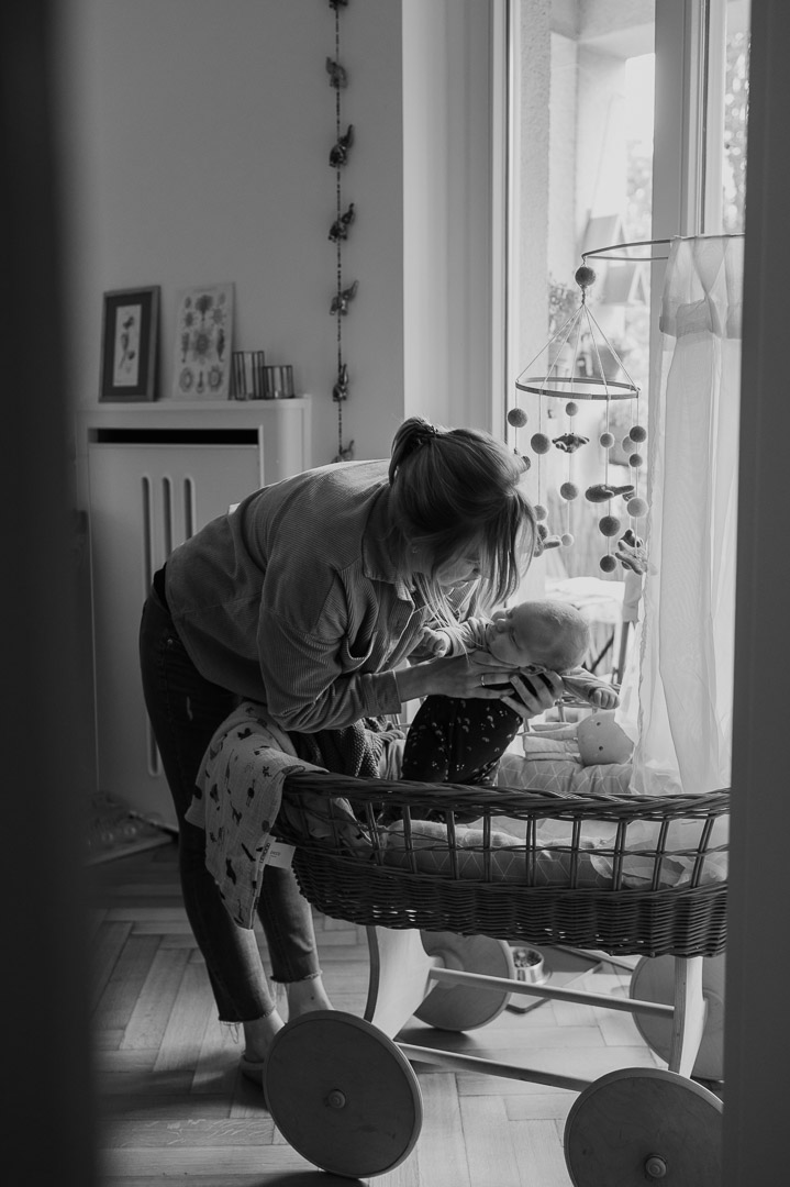 Mama legt Baby in Wiege