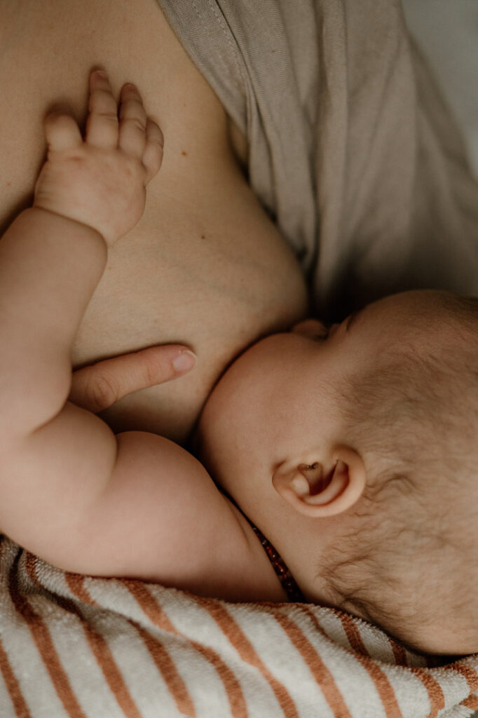 Baby wird an Brust gestillt